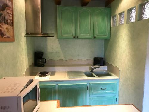RussL'estaminet de la vallée - Le provençal的厨房配有绿色橱柜和水槽