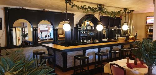 兰格尔斯海姆拉丰塔纳酒店的餐厅内的酒吧,配有桌椅