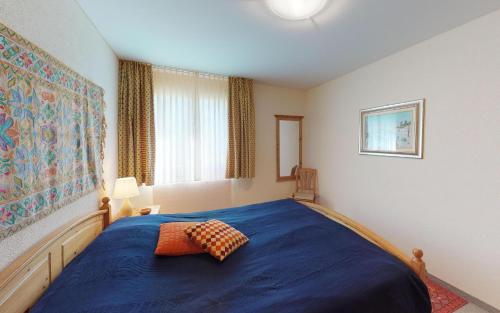 圣莫里茨Surpunt 44的一间卧室设有蓝色的床和窗户。