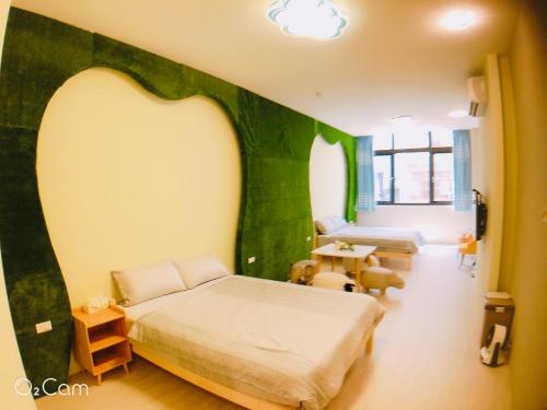 台南格林薇依的一间卧室设有绿色的墙壁、一张床和一张桌子