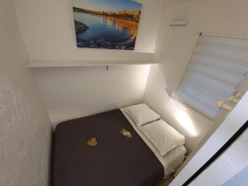 戛纳T2 rez de jardin front de mer的一张小床,位于一个小房间里,配有绘画作品