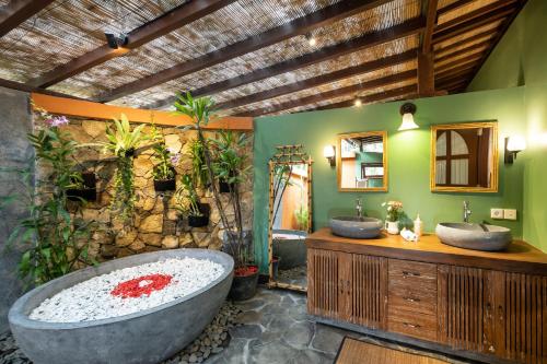 乌布Villa Uma Anyar- Joglo Uma的一间带两个盥洗盆和大浴缸的浴室