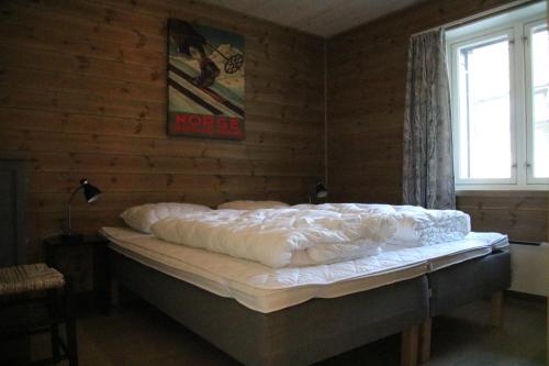 VossestrandMyrkdalen Resort Årmotssteien的一张位于带四柱床的墙上的床铺