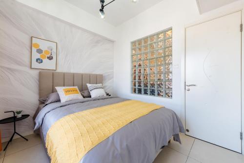 西安【路客】西安市莲湖区·北大街假日国际公寓·路客精品民宿·00181110的一间卧室配有一张黄色毯子床