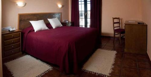 Cuesta de la Palma德尔波尼恩特田园酒店的一间卧室配有一张紫色床、梳妆台和椅子