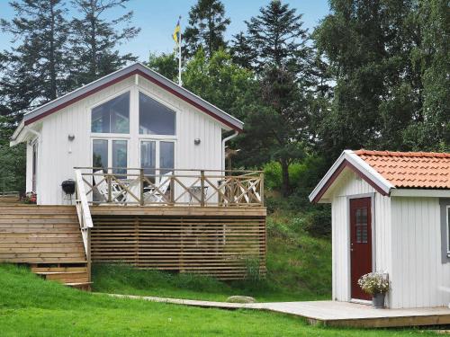 斯泰农松德4 person holiday home in STENUNGSUND的白色的小小屋,设有甲板和房屋