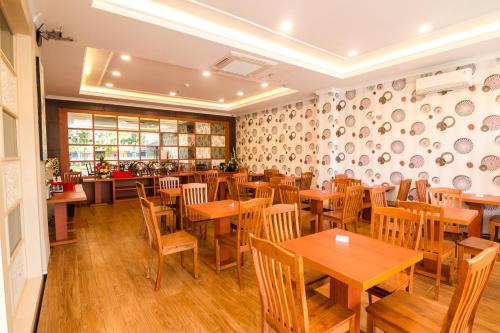 巴淡岛中心Blitz Hotel Batam Centre的餐厅设有木桌和木椅