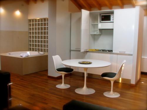 帕尔马Parizzi Suites & Restaurant的厨房配有桌椅和浴缸。
