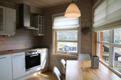 VossestrandMyrkdalen Resort Nedre Byggardslii apartment的厨房配有桌子、炉灶和窗户。