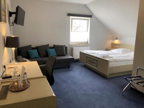 瓦尔拉夫施万祖姆诺恩酒店的一间带床和沙发的小卧室