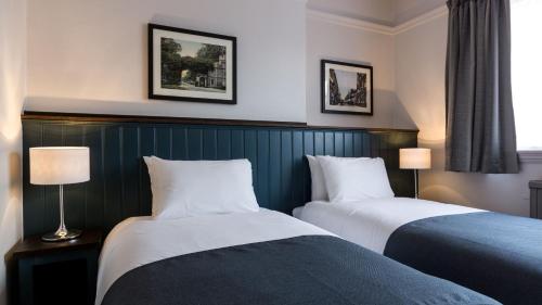 沃特福德南十字旅馆的酒店客房设有两张床和两盏灯。