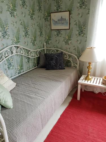 RimboThe brickmaker's cottage的一间卧室配有一张床,铺有红色地毯