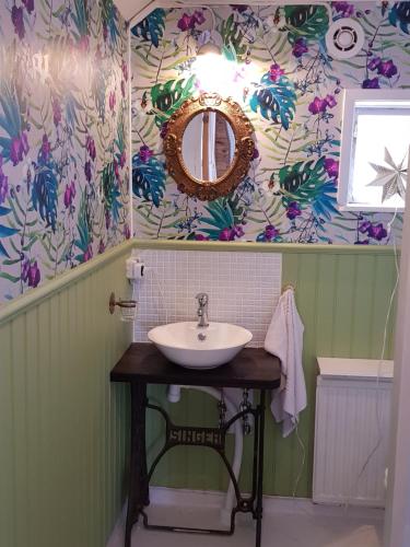 RimboThe brickmaker's cottage的一间带水槽和花卉壁纸的浴室