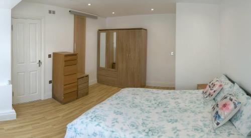 泰晤士河畔金斯顿Spacious 2-bed apartment in central Kingston near Richmond Park的一间卧室配有一张床和一个木制梳妆台