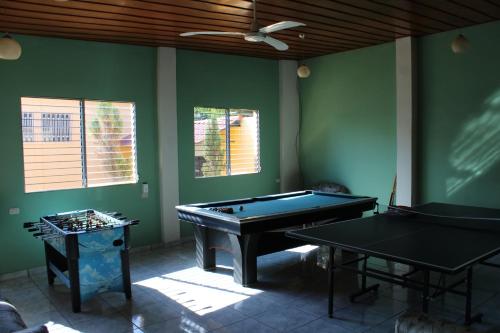 康塞普西翁德阿塔科Las Casitas Hostal-Ataco的绿墙客房内的两张乒乓球桌