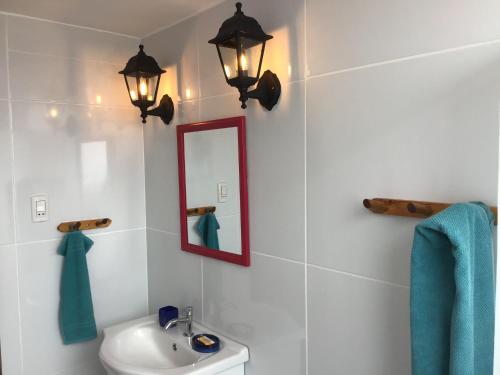 普库萨纳Cruz del Sur的浴室设有水槽、镜子和灯