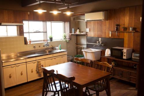 Shimo-yugeGuest House tokonoma的厨房配有桌椅和水槽。