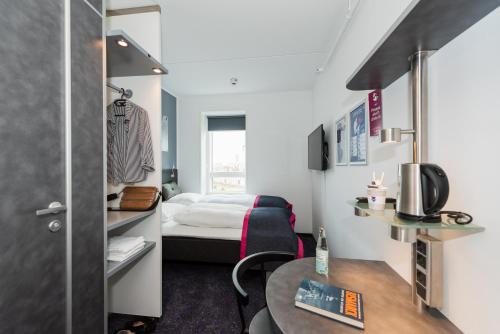 哥本哈根Cabinn Copenhagen的小房间设有一张床和一张桌子