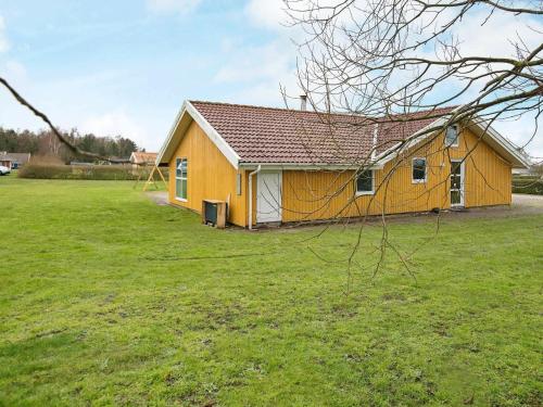 诺德堡12 person holiday home in Nordborg的草地上的黄色房子