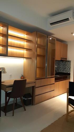 当格浪Studio Suite Roseville @ BSD City, Great Location的厨房配有木制橱柜和桌椅