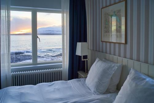托尔斯港哈夫格林海滨1948酒店的一间卧室设有一张床和一个大窗户
