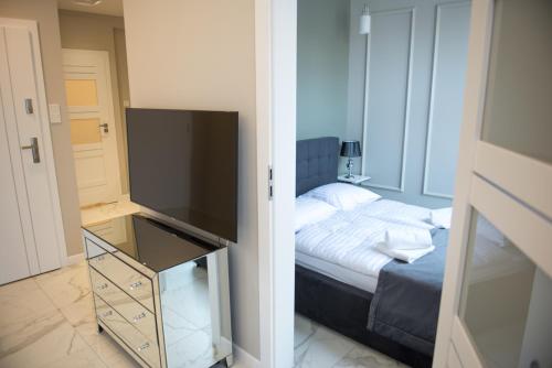 科沙林Apartamenty Prestiż 91的一间卧室配有一张床和一台电视。