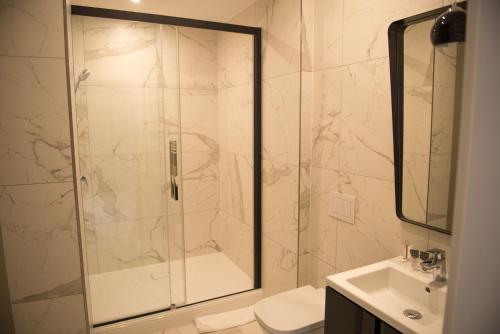 科沙林Apartamenty Prestiż 91的带淋浴、卫生间和盥洗盆的浴室