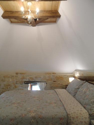 CarluxLa Petite Tour的一间卧室配有一张床和一个吊灯