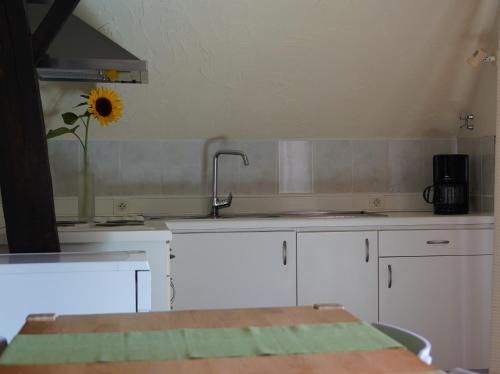 Kortessem鲁特蒙恩度假屋的厨房配有水槽和墙上的向日葵