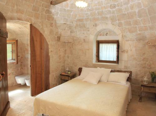 阿尔贝罗贝洛Pietraluce的卧室配有一张石墙内的大床