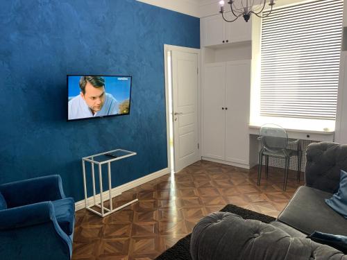第聂伯罗Квартира Титова 12的客厅配有沙发和蓝色墙壁上的电视