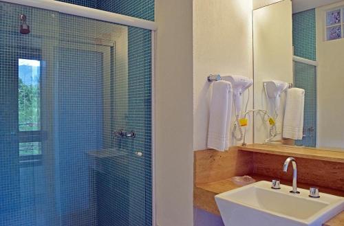 伊利亚贝拉Bella Ilha Pousada的一间带水槽和玻璃淋浴的浴室
