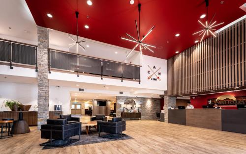 基洛纳Hotel Kelowna & Conference Centre的大堂设有红色天花板和黑色椅子。