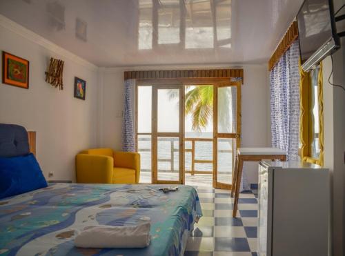 普罗维登西亚Posada Ocean View的卧室配有床、椅子和窗户。