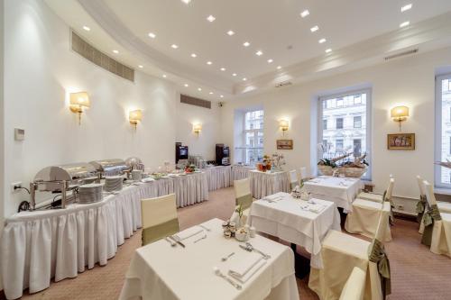 圣彼得堡金三角精品酒店 的一间带桌子和白色桌布的用餐室