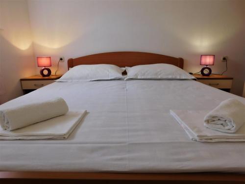 贝蒂纳Charming apartment Karlo的一张白色大床,带两条毛巾和两盏灯