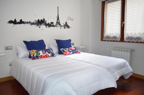 希洪Piso Céntrico y Moderno的卧室配有带蓝色枕头的大型白色床