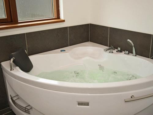 托斯明德8 person holiday home in Ulfborg的浴室内设有带水槽的白色浴缸