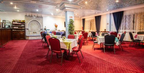 舍夫沙万塔里克酒店的一间铺有红地毯并配有桌椅的用餐室