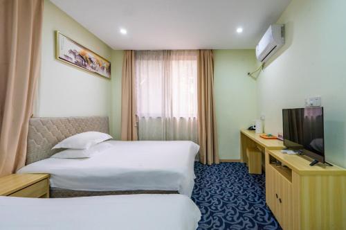 杭州Hangzhou Memory Travel International Hotel-Edge Westlake的酒店客房设有两张床和电视。