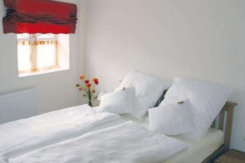 WilsterGästehaus Oh-La-La的白色的床、白色枕头和窗户