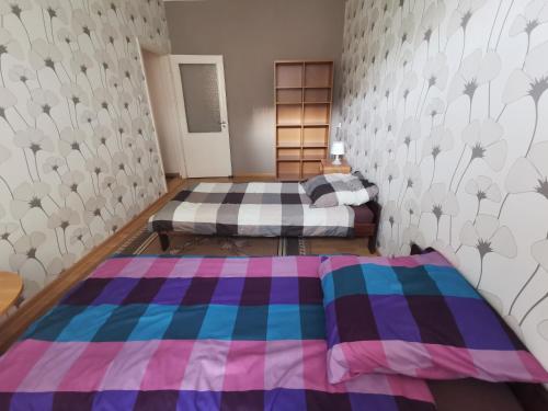 科希切日纳Apartament nr 3 w Starym Nadleśnictwie的一间卧室设有两张床和鲜花墙