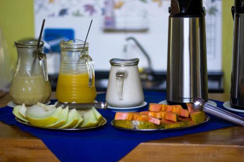 诺布里斯Pousada Rota das Águas的一张桌子,上面放两盘水果和果汁