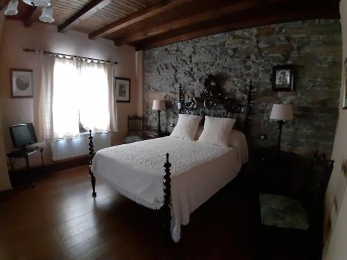 Portela de PortomouriscoCasa Portela的一间卧室设有一张床和石墙