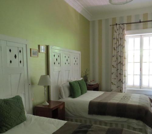 圣克鲁兹Hotel Boutique Quinta Maria的一间卧室设有两张床和窗户。