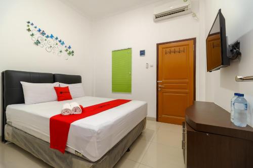 井里汶RedDoorz near Kejaksan Station Cirebon 2的一间卧室配有一张床和一台电视