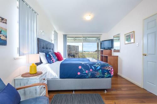 丹马克冲浪道海滩丹麦度假屋的一间卧室配有一张特大号床和一台电视