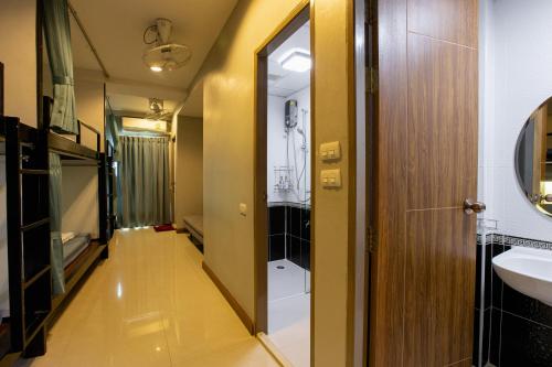 曼谷瑞思提尼旅舍的走廊上的浴室设有水槽和镜子