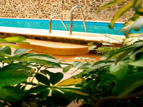 休达Oh Nice Ulises Ceuta的游泳池旁的木凳