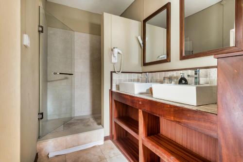 埃斯尼角Villa Vakoa - Tranquil Villa With Lush Gardens的一间带两个盥洗盆和淋浴的浴室